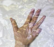 Hand of a young female wrapped in plastic film showing different gestures photo