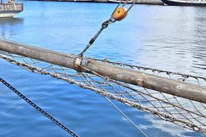 Sailing ship mast against the blue sky on some sailing boats with rigging details. photo