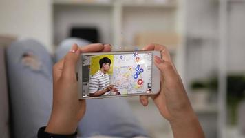 gros plan sur le mobile d'une femme regardant un smartphone à la maison. homme asiatique diffusant une vidéo diffusée en direct sur un mobile à écran avec beaucoup d'emoji et d'amour émotionnel.