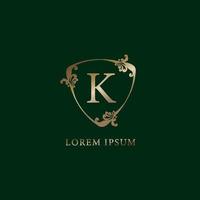 Letter K Alphabetic logo design template. Luxury gold decorative floral shield sign illustration. Insurance logo concept isolated on dark green background vector