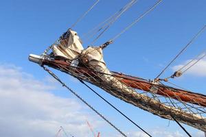 Sailing ship mast against the blue sky on some sailing boats with rigging details. photo