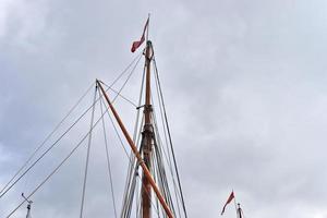 Sailing ship mast against the blue sky on some sailing boats with rigging details. photo