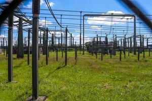 Electrical Transformer. Distribution of electric energy at a big substation with lots power lines on a sunny day photo