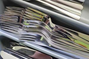 Selective focus of shiny cutlery in a dishwasher after cleaning. Forks, Knifes and Spoons photo