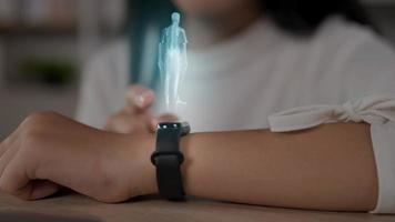 close-up da mão feminina com smartwatch futurista interage com um holograma hud. mulher usa tecnologia holográfica do futuro em um relógio de pulso. conceito médico e estilo de vida. video