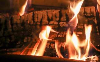 Beautiful red and orange hot burning fire in a fireplace photo