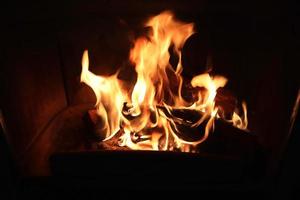 Beautiful red and orange hot burning fire in a fireplace photo