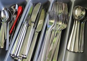 Selective focus of shiny cutlery in a dishwasher after cleaning. Forks, Knifes and Spoons photo
