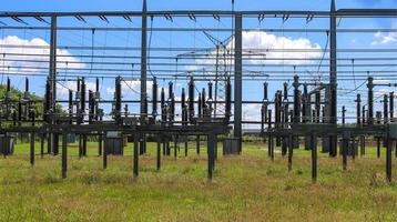 Electrical Transformer. Distribution of electric energy at a big substation with lots power lines on a sunny day photo