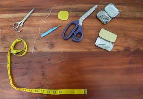 Sewing concept. Different sewing accessoires on a brown wooden background. photo