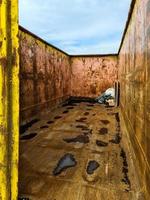 View into an almost empty very rusty industrial garbage container. photo