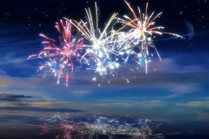 Beautiful happy new year fireworks in the sky with reflections on water photo