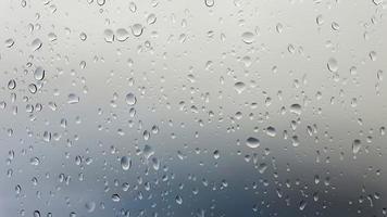 gotas de lluvia corriendo por una ventana en una vista de primer plano. foto