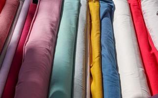 Detailed close up view on samples of cloth and fabrics in different colors found at a fabrics market photo