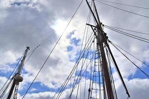 Sailing ship mast against the blue sky on some sailing boats with rigging details. photo