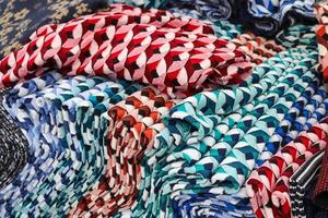 Detailed close up view on samples of cloth and fabrics in different colors found at a fabrics market photo