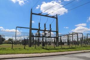 Electrical Transformer. Distribution of electric energy at a big substation with lots power lines on a sunny day photo