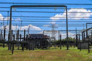 Electrical Transformer. Distribution of electric energy at a big substation with lots power lines on a sunny day photo