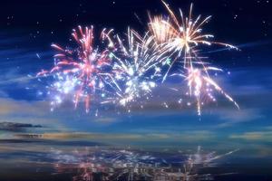 Beautiful happy new year fireworks in the sky with reflections on water photo