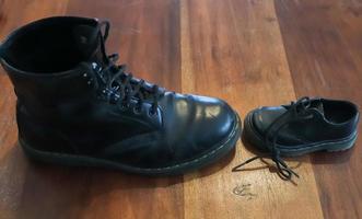 Big and small old black leather shoe on a wooden floor photo