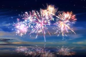 Beautiful happy new year fireworks in the sky with reflections on water photo