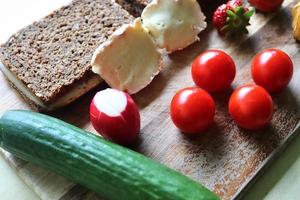 vista cercana de un saludable desayuno alemán con sándwiches, tomates y pepinos foto