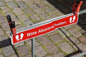 Mantenga el símbolo de distancia en alemán Señal de distanciamiento social de 2 metros para covid 19. foto