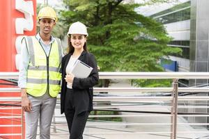 Group of Engineer Worker Wearing Safety Uniform and Hard Hat Uses Tablet Computer. Happy Successful. Businesswomen working with tablet checklist. Portrait of male worker wearing hard hat photo