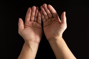 The man whose hand is praying for a blessing with a black background photo