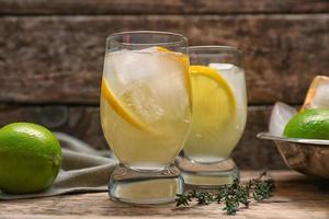 Refreshing cocktails with lemon on wooden table