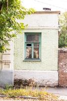 Part of the house with a window in the summer street photo