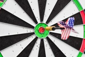 Dart arrow hitting in the target center of dartboard photo