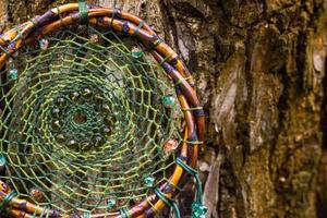 Dreamcatcher made of feathers, leather, beads, and ropes photo