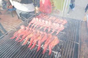 enfoque selectivo en alas a la parrilla, sobre carbón de leña y ahumado, especialidades malasias, festival de comida callejera foto