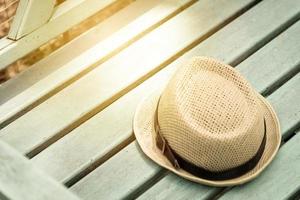 Brown hat on green wooden bench in the park photo