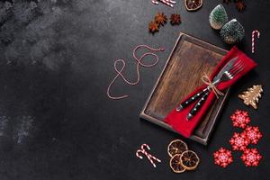 Christmas table setting with empty black ceramic plate, fir tree and black accessories photo