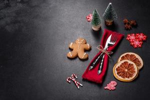 Christmas table setting with empty black ceramic plate, fir tree and black accessories photo