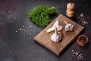 Heads of fresh white garlic on a wooden cutting board