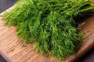 A bunch of fresh green dill on a wooden cutting board