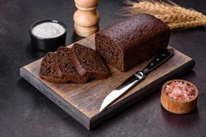 Sliced rye bread on cutting board. Whole grain rye bread with seeds photo