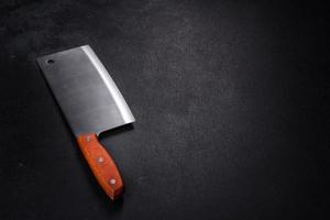 An axe for cutting meat on a dark concrete background photo
