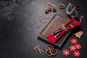 Christmas table setting with empty black ceramic plate, fir tree and black accessories photo