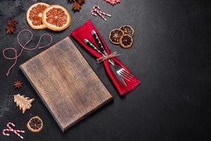 Christmas table setting with empty black ceramic plate, fir tree and black accessories photo