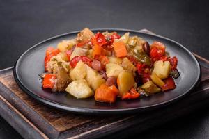 Vegetable stew or ratatouille with eggplant, tomatoes, sweet and hot peppers, onions, carrots and spices in plate photo