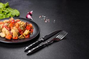 Vegetable stew or ratatouille with eggplant, tomatoes, sweet and hot peppers, onions, carrots and spices in plate photo