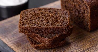 Sliced rye bread on cutting board. Whole grain rye bread with seeds photo