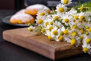 ramo de flores de manzanilla de jardín sobre una mesa de hormigón amarillo foto