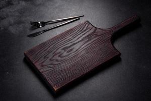 An empty plate with a knife, fork or spoon with a wooden cutting board photo