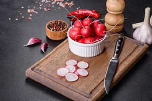 Delicious fresh red radish as ingredient to make spring salad on wooden cutting board