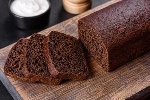 Sliced rye bread on cutting board. Whole grain rye bread with seeds photo